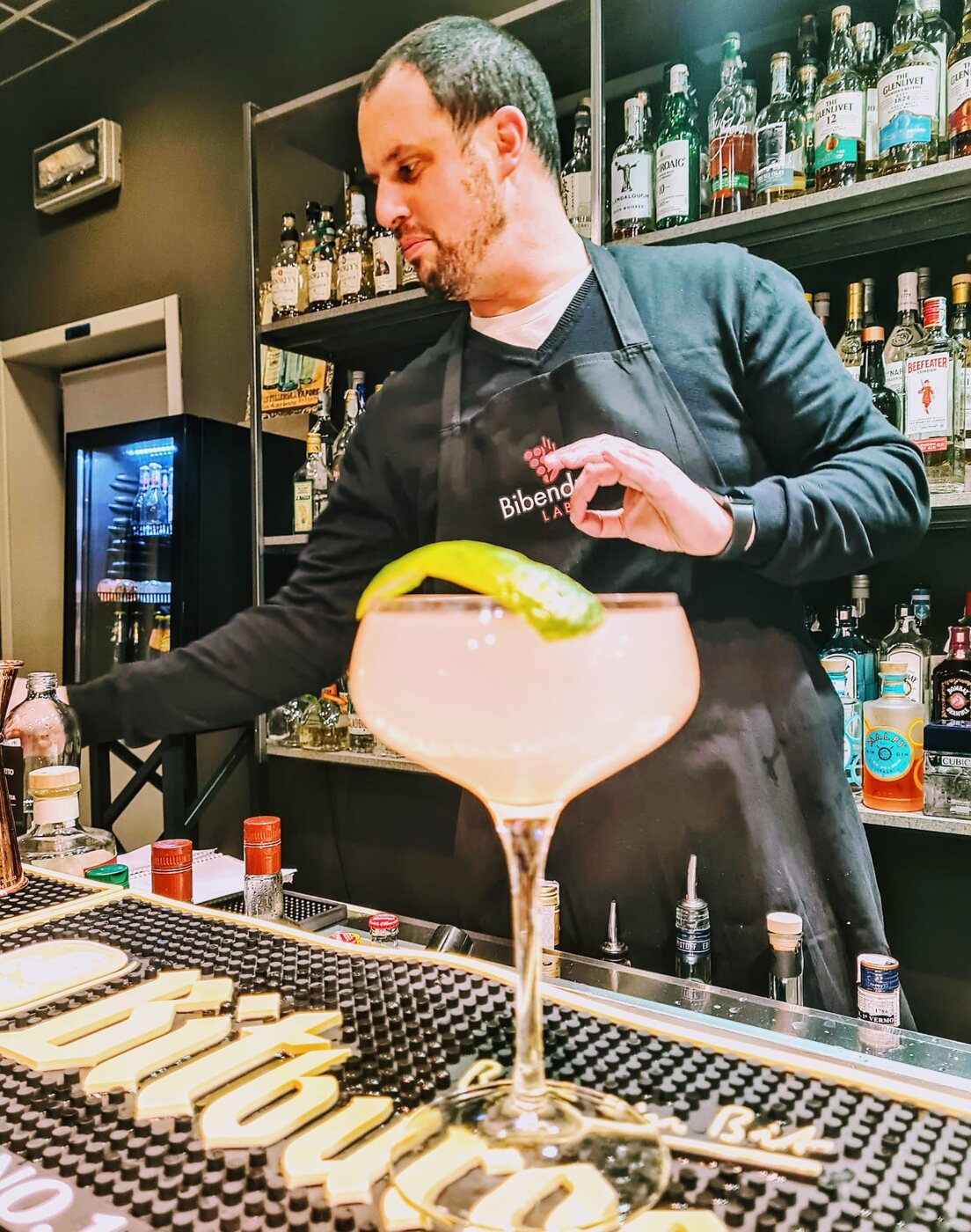 Un barman di Bibendum Lab prepara un cocktail al bancone della scuola